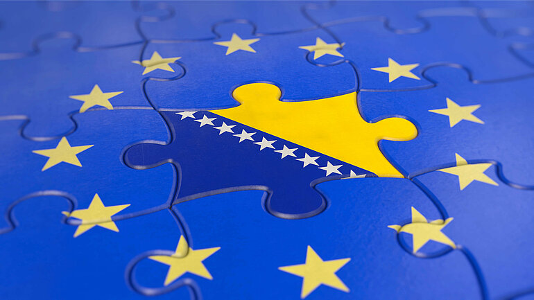 Die Flagge von Bosnien und Herzegowina in einem blauen Puzzle mit gelben Sternen
