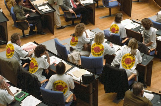 Die Abgeordneten von Bündnis 90/Die Grünen sitzen 1994 im Deutschen Bundestag, sie sind von hinten zu sehen und tragen T-Shirts mit dem Aufdruck "Atomkraft? Nein Danke!"