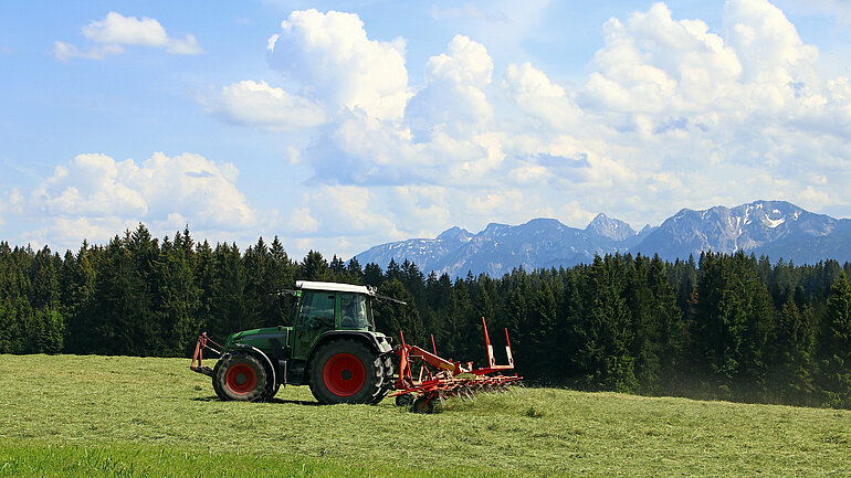 Mowing in summer on a field in Bavaria. Agricultural work in summer