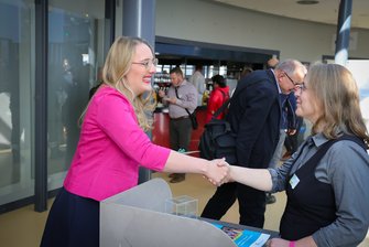 Katharina Dröge gibt einer Referentin am Stand der Stiftung Bildung die Hand