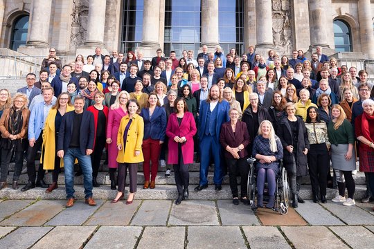 Die Fraktion von Bündnis 90/Die Grünen als Gruppenfoto vor dem Reichstagsgebäude. Die Abgeordneten stehen in Reihen hintereinander auf einer Treppe.