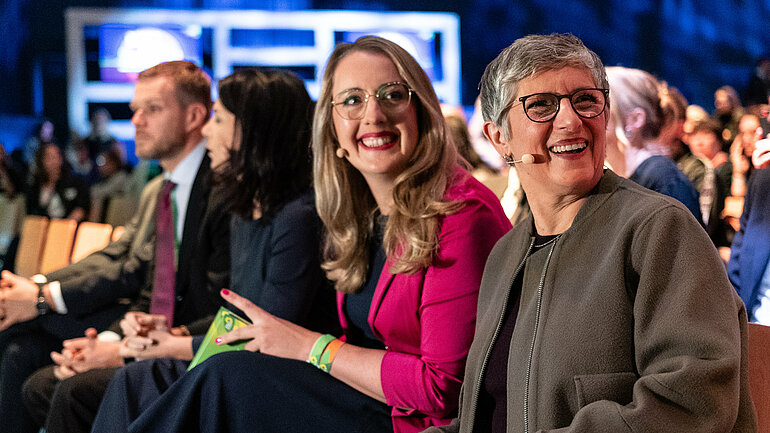 Die Co-Fraktionsvorsitzenden Katharina Dröge und Britta Haßelmann sitzen nebeneinander beim Auftaktpanel