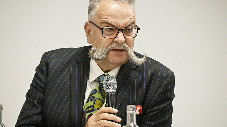 Der Generaldirektor des Berliner Naturkundemuseums Ph.D. Johannes Vogel sitzt an einem Tisch und spricht in ein Mikrofon.