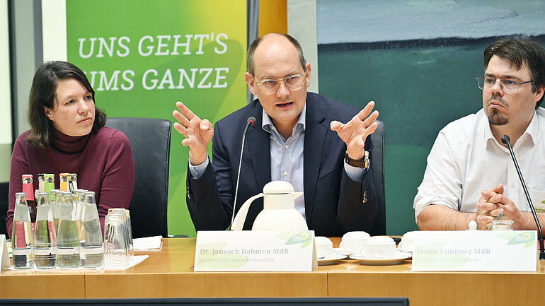 Die Abgeordneten Linda Heitmann, Dr. Janosch Dahmen und Helge Limburg sitzen nebeneinander an einem Tisch..