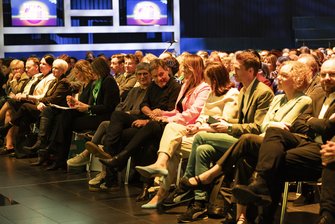 Ein gefüllter Saal, ein Publikum vor einer Bühne