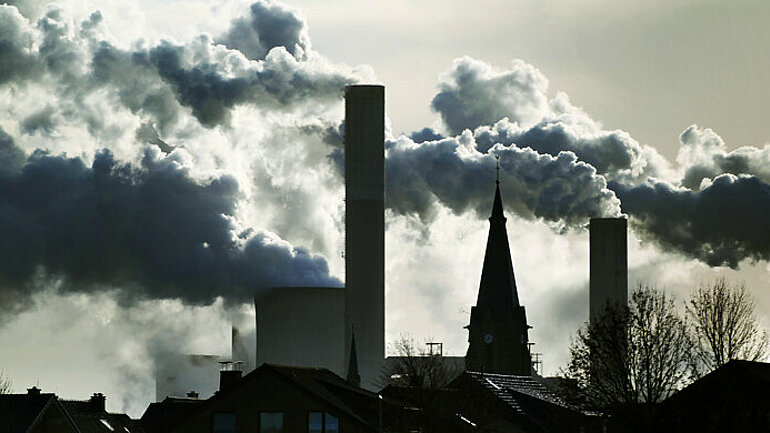 Rauch und Dampf steigt aus den Kühltürmen und Schornsteinen des RWE-Braunkohlekraftwerks Frimmersdorf bei Grevenbroich.