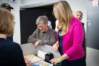 Britta Haßelmann und Katharina Dröge stehen nebeneinander an einem Stand