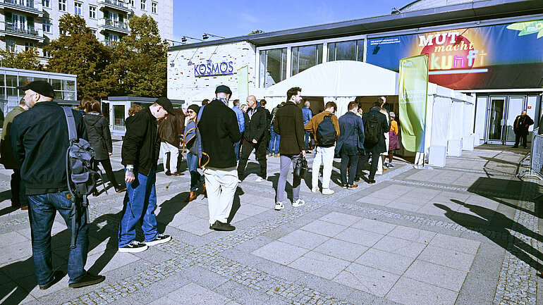 Viele Personen stehen in einer Schlange an einer Sicherheitskontrolle an. 