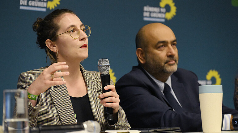 Deborah Düring MdB und Omid Nouripour, Bundesvorsitzender Bündnis 90/Die Grünen sitzen nebeneinander, Deborah Düring spricht in ein Mikrofon.