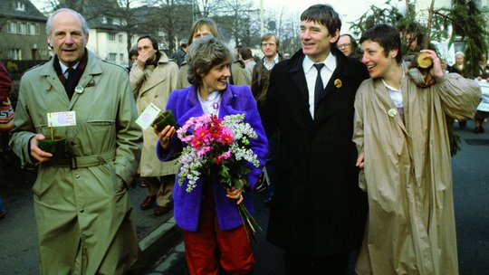 Gert Bastian, Petra Kelly, Otto Schily und Marieluise Beck gehen nebeneinander.