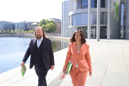 Katrin Göring-Eckardt und Anton Hofreiter laufen im Regierungsviertel an der Spree entlang