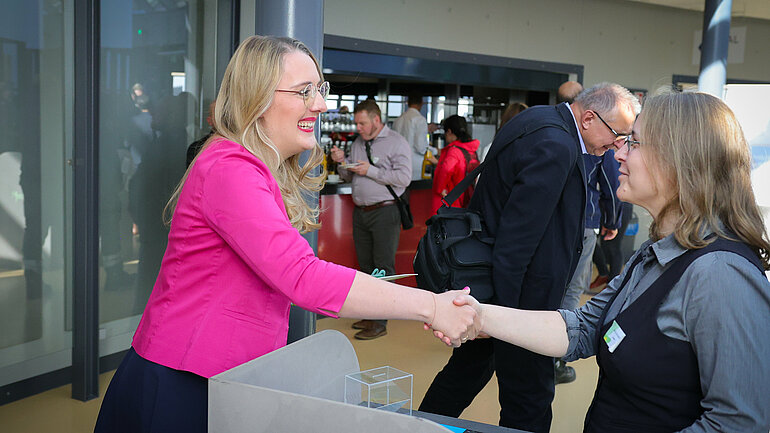 Katharina Dröge begrüßt die Referentin am Stand der Stiftung Bildung